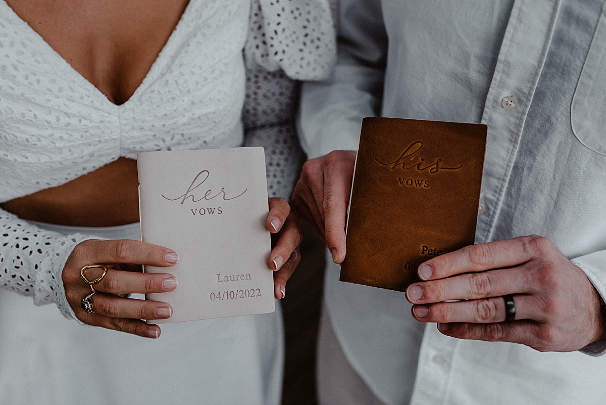 bride and groom holding their vow booklets