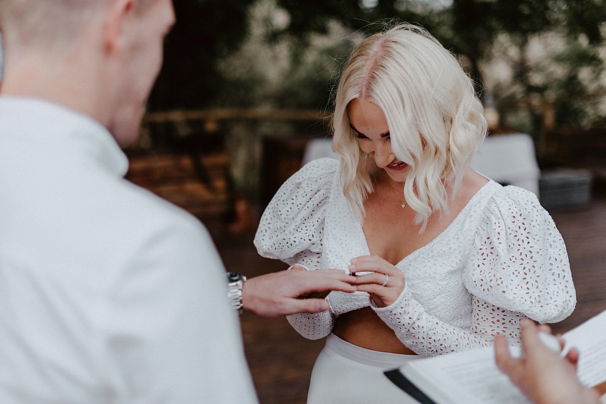 bride placing ring on grooms finger
