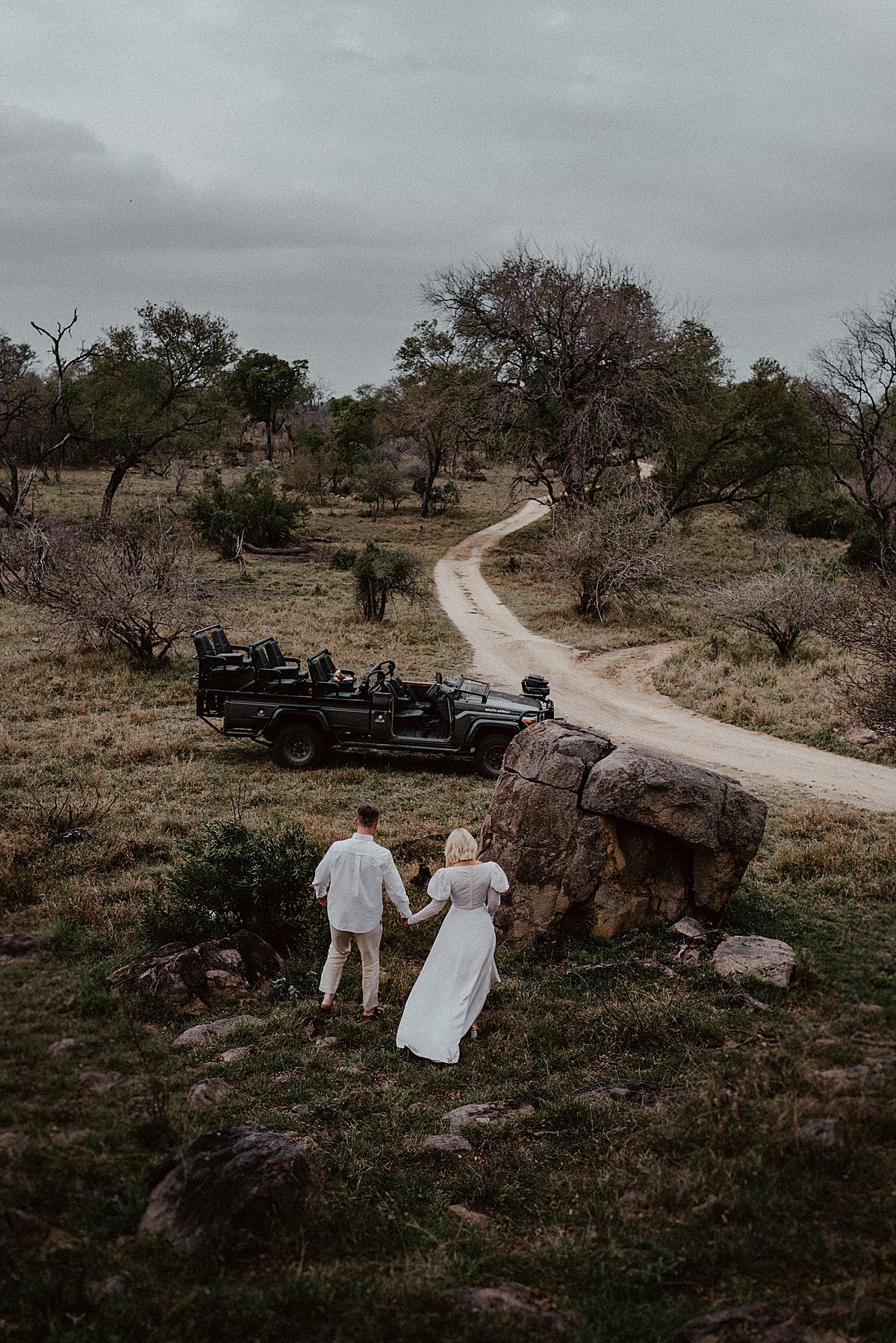 bride and groom walking towards lion sands safari vehicle