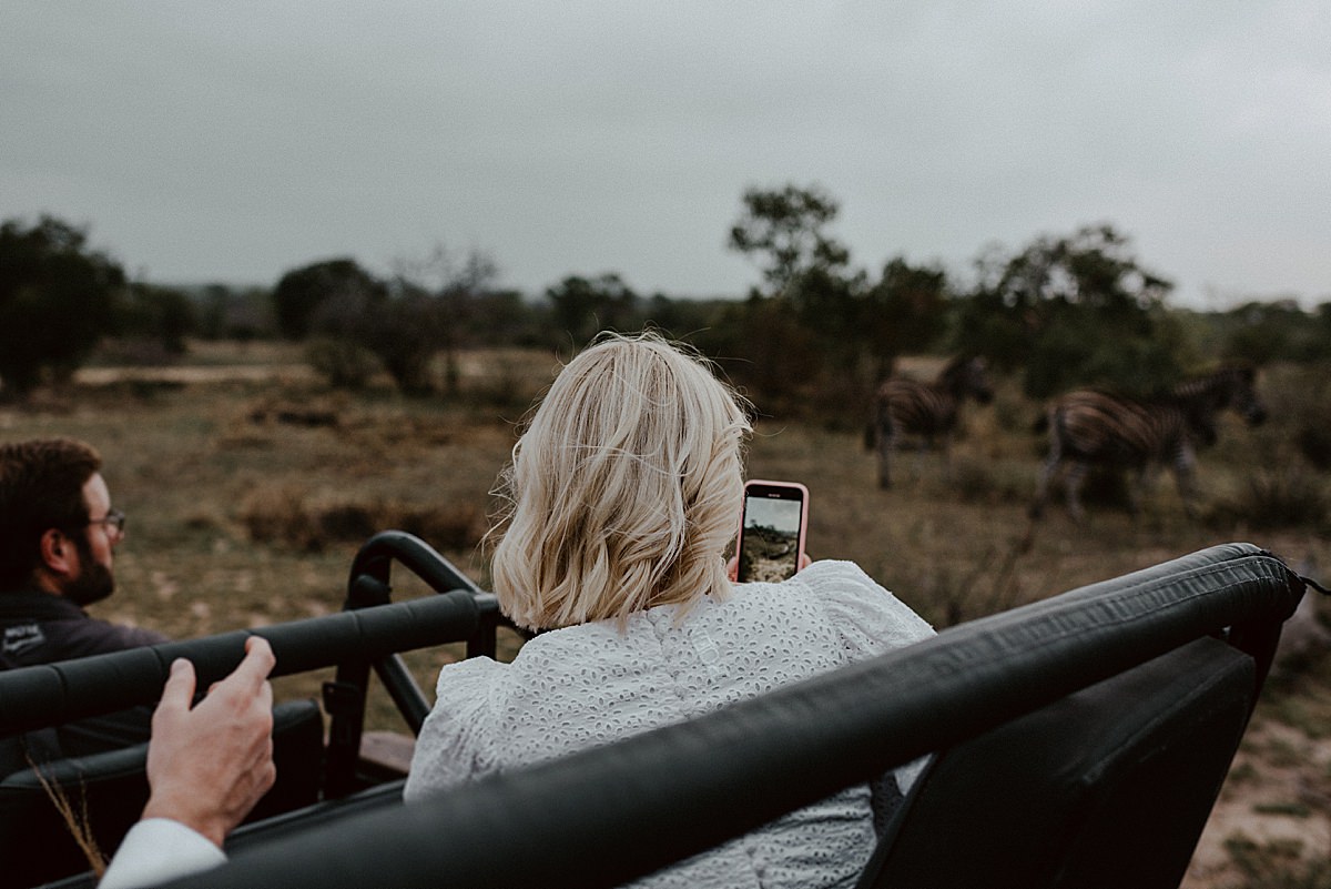bride photographing animals from safari vehicle